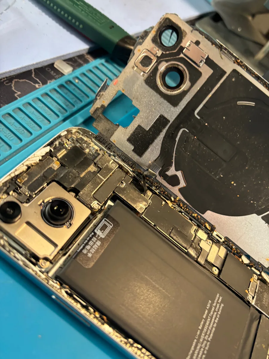 Back cover iPhone separata dal telaio con moduli fotocamera e adesivi visibili