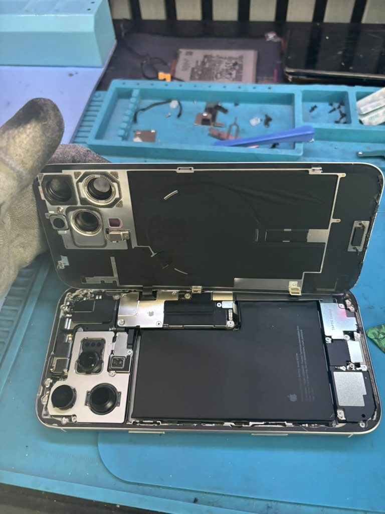 iPhone 12 aperto con display sollevato durante sostituzione batteria