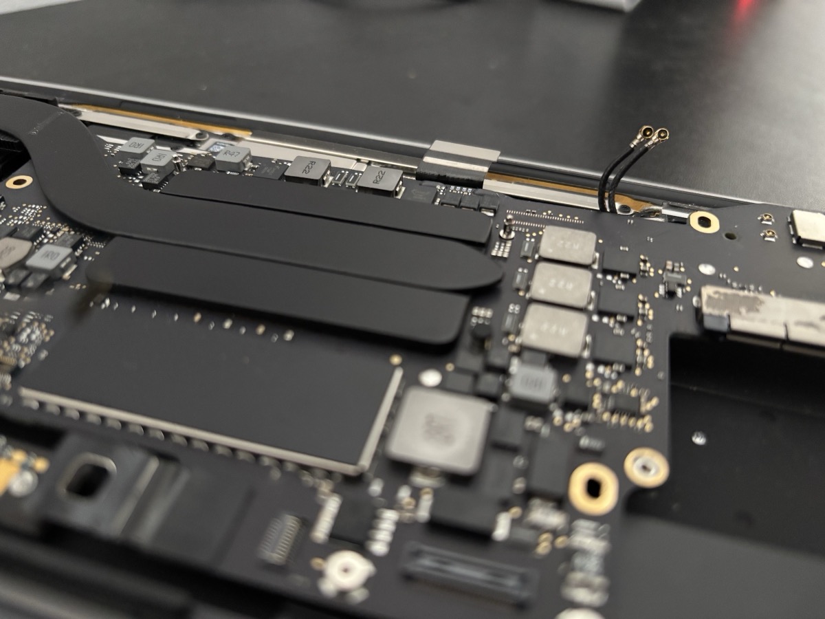 Scheda logica MacBook aperta in riparazione nel laboratorio di Torino